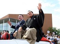 　昇進祝賀パレードで歓声に応える横綱大の里。左は二所ノ関親方