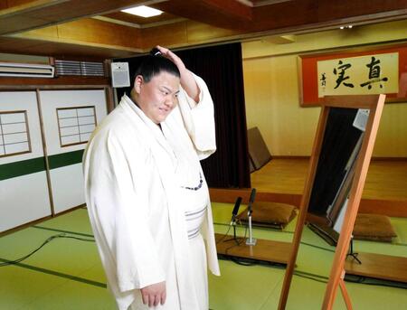 　ちょんまげ姿を鏡で確認する草野