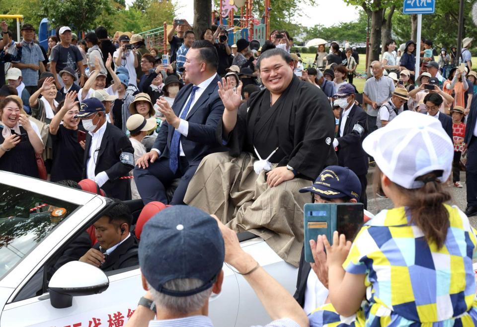 　昇進祝賀パレードで沿道の声援に応える横綱大の里。左は二所ノ関親方（撮影・星野大輔）