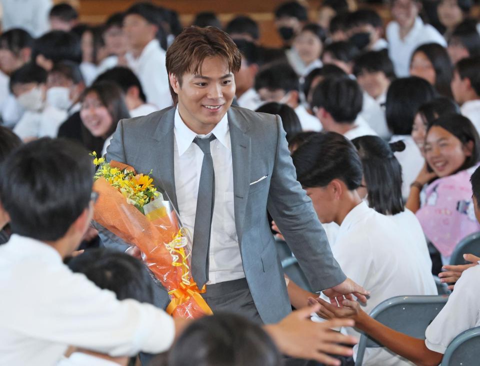 　特別授業を終え、生徒たちとタッチを交わして会場を後にする阿部一二三（撮影・立川洋一郎）