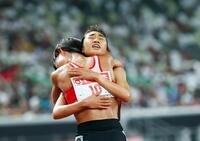 　女子５０００メートルで優勝を決め広中璃梨佳と抱き合う田中希実（奥）