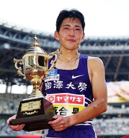 　男子８００メートルで優勝し、トロフィーを手にする落合晃　