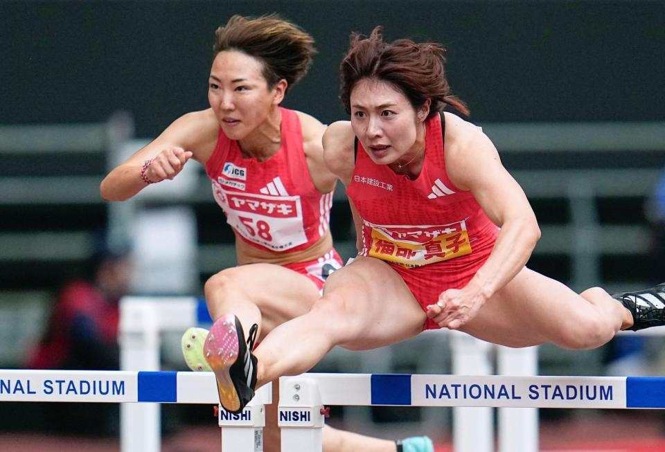　女子１００メートル障害準決勝で力走する福部真子。左は寺田明日香