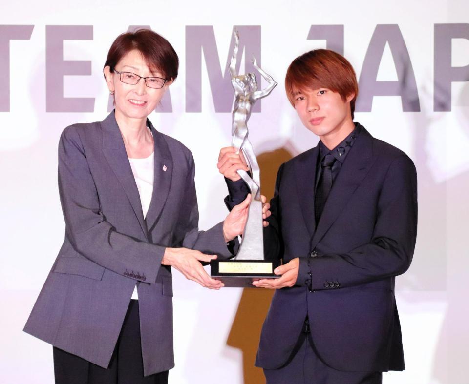 　ＪＯＣの三屋裕子副会長（左）からトロフィーを受け取った堀米雄斗