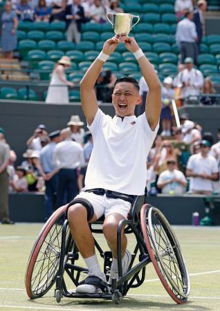　車いすの部男子シングルスで優勝し、トロフィーを掲げる小田凱人＝ウィンブルドン（共同）