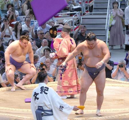 　安青錦（左）に渡し込みで敗れ、座布団が舞う中を引き揚げる豊昇龍