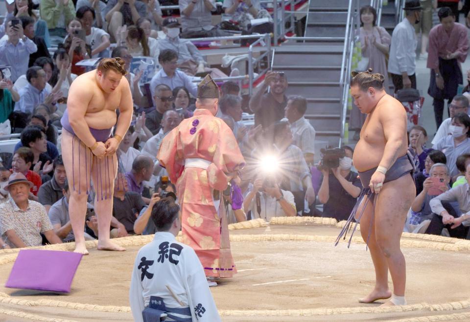 　安青錦（左）に渡し込みで敗れ、座布団が舞う中を引き揚げる豊昇龍