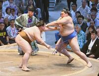 　王鵬（左）が押し出しで大の里を破る