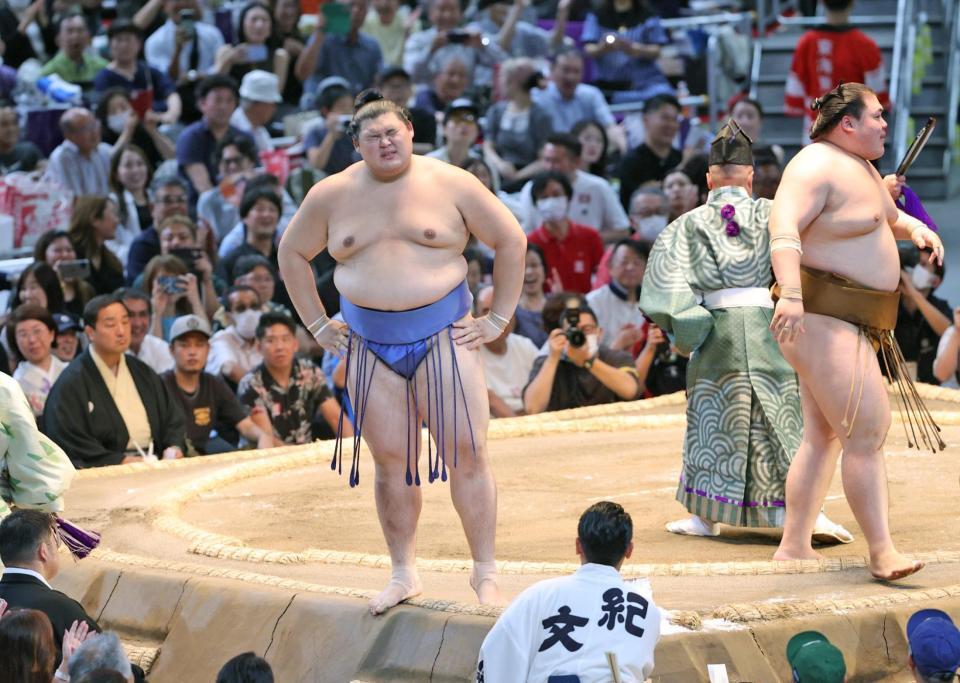 　王鵬（右）に押し出しで敗れ、厳しい表情を見せる大の里