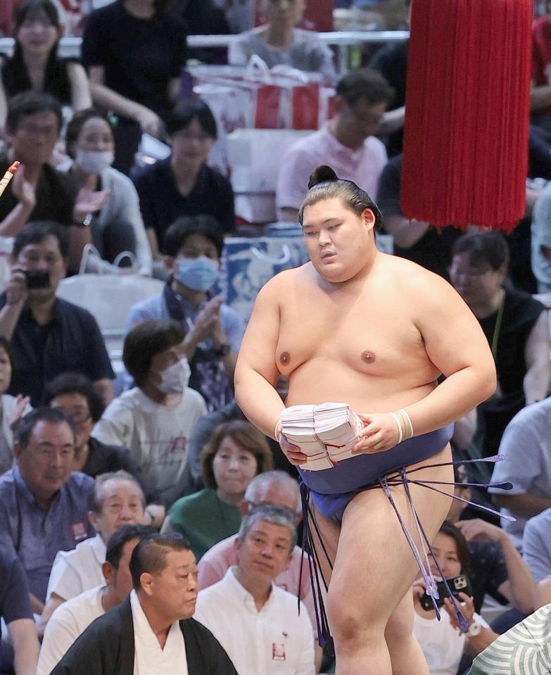 　金峰山を下し、懸賞金の束を手に引き揚げる大の里