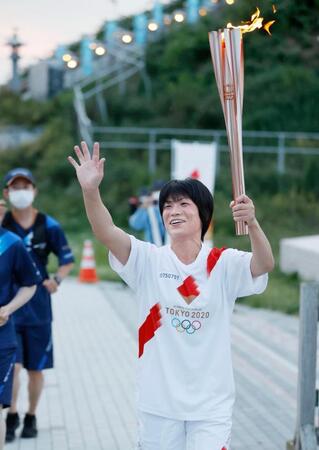 　聖火のトーチを手に笑顔を見せる、ロンドン五輪女子レスリング金メダリストの小原日登美さん＝２０２１年６月