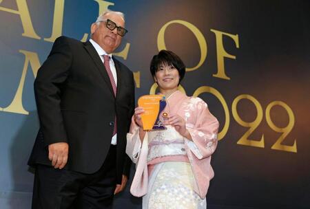 　世界レスリング連合から殿堂入りの表彰を受ける小原日登美さん（右）＝２０２２年９月（共同）