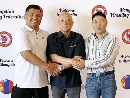 　レスリングのモンゴル代表総監督就任が決まり、関係者と握手する栄和人氏（中央）＝２３日、ウランバートル（本人提供）
