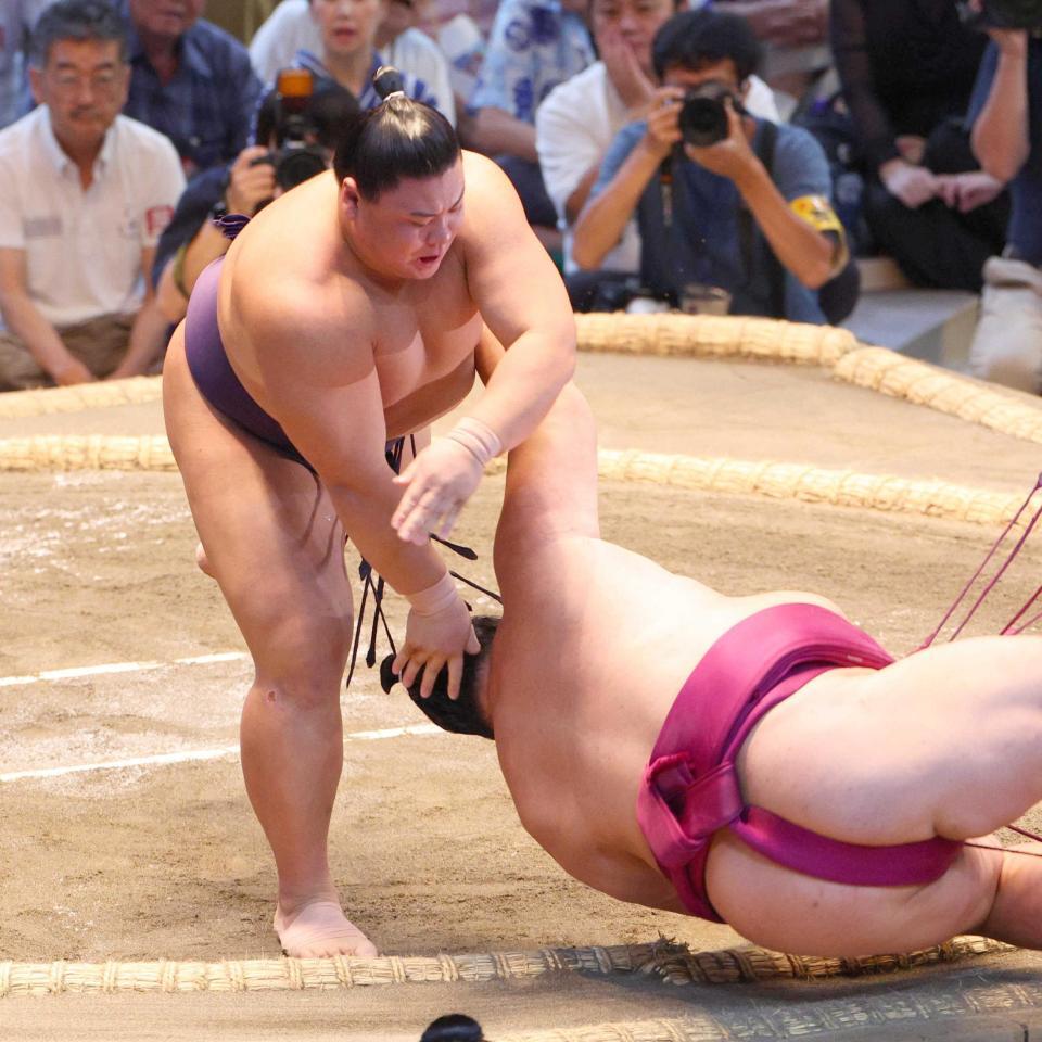 　上手投げで御嶽海を破る草野（左）