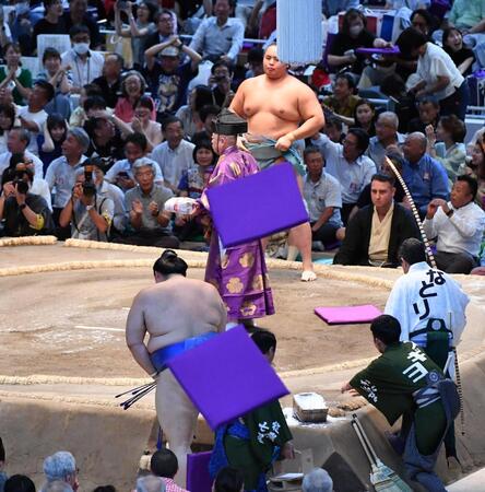　琴勝峰（後方）に上手投げで敗れ４敗目を喫し、座布団が投げ込まれる土俵に戻る大の里（撮影・開出牧）