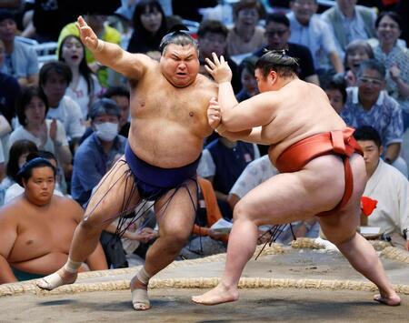 　熱海富士（右）の攻めをこらえる高安。下手投げで破る