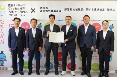 　プロチームとの連携協定の締結式で、記念写真に納まる（左から）兵庫県西宮市の石井登志郎市長、阪神の粟井一夫社長、Ｊ１神戸の千布勇気社長ら＝２９日、西宮市役所