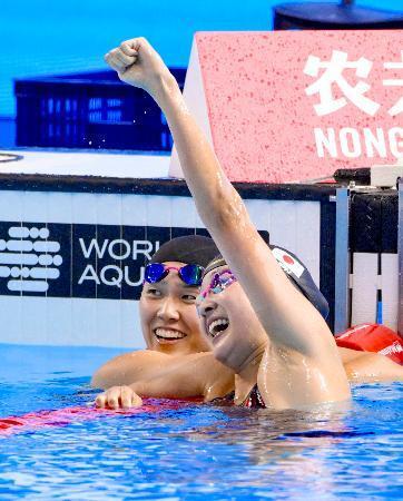 　女子４００メートル個人メドレーで銀メダルを獲得しガッツポーズする成田実生。左は小堀倭加＝シンガポール（共同）