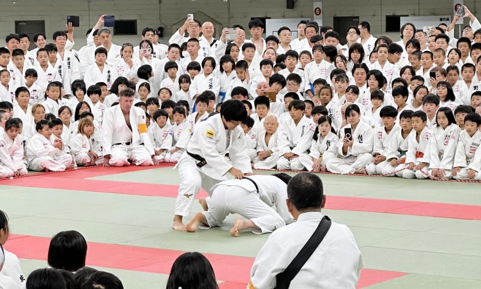 　全日本少年少女武道錬成大会で寝技を解説する嘉重（中央）
