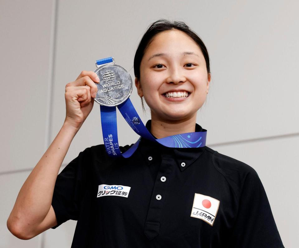 　世界水泳選手権から帰国し、銀メダルを掲げる競泳女子の成田実生