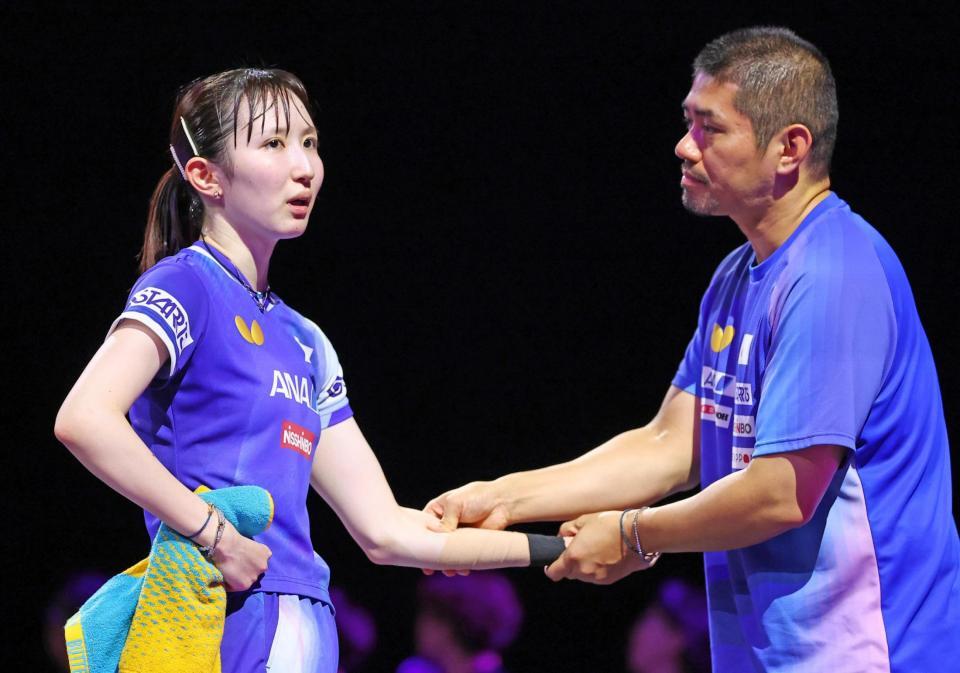 　コーチ（右）から左腕のマッサージを受ける早田ひな