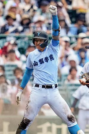 　山梨学院-岡山学芸館　５回表、適時三塁打を放ち拳を突き上げる山梨学院・菰田＝甲子園