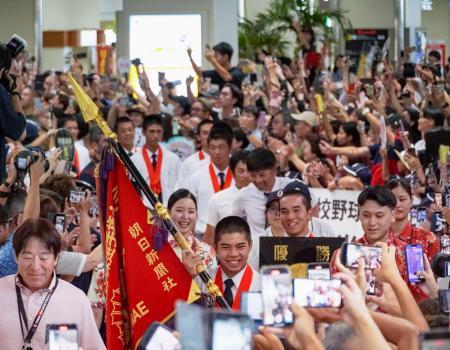 　夏の甲子園で初優勝を果たし、多くの人が出迎える中、那覇空港に到着した沖縄尚学高野球部の選手ら＝２４日午後