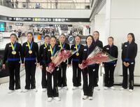 　笑顔で成田空港に帰国した鈴木歩佳主将（前列左）、村田本部長（前列右）ら