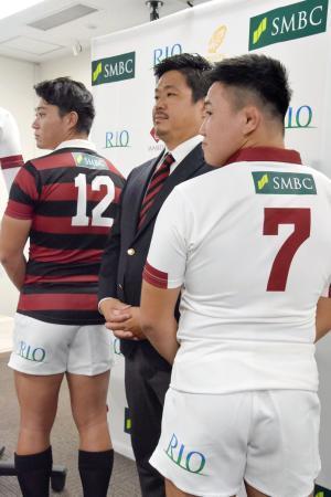 　スポンサーのロゴ入りのラグビー部ジャージーを披露する早大の野中健吾主将（左）ら。中央は大田尾竜彦監督＝４日、東京都内
