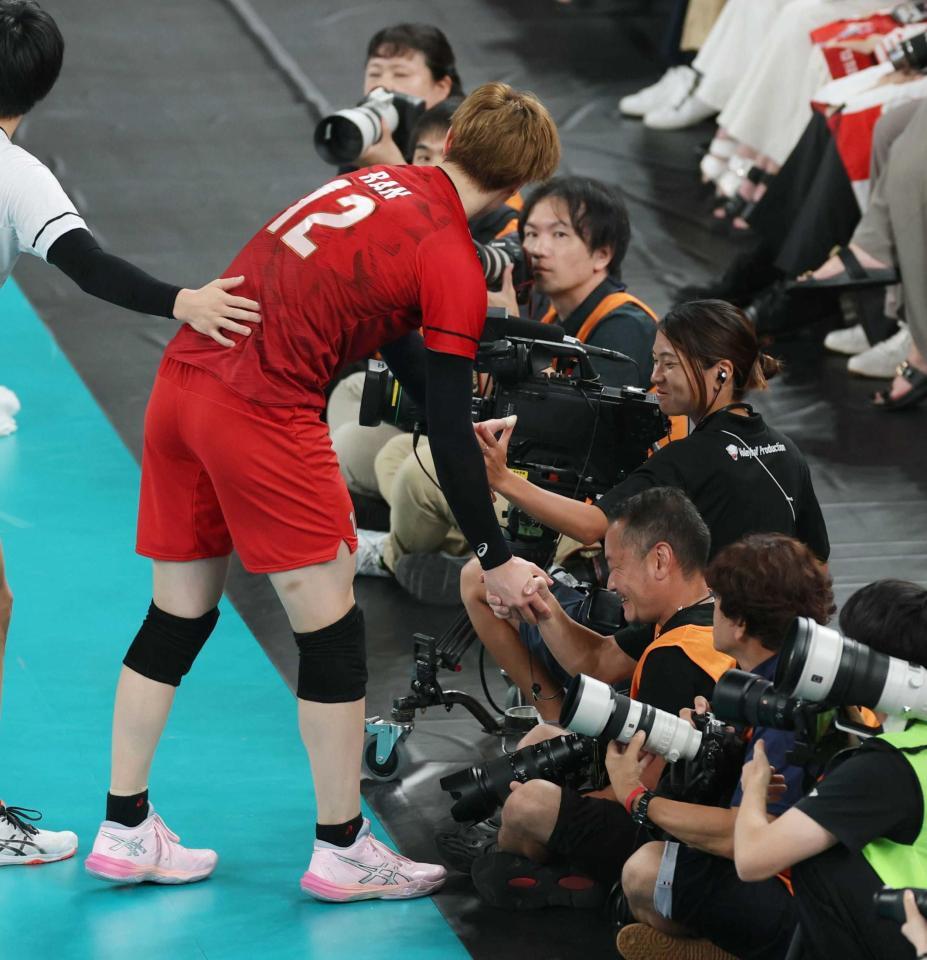 　ぶつかったカメラマンと握手を交わす高橋藍