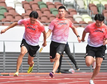 　バトンパスの練習をする鵜沢飛羽（左）と桐生祥秀（代表撮影）