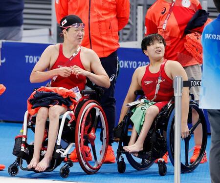 　東京五輪・女子１００メートル自由形（運動機能障害Ｓ５）予選のレースを終え、電光掲示板で結果を確認する成田真由美さん（左）と由井真緒里＝２０２１年