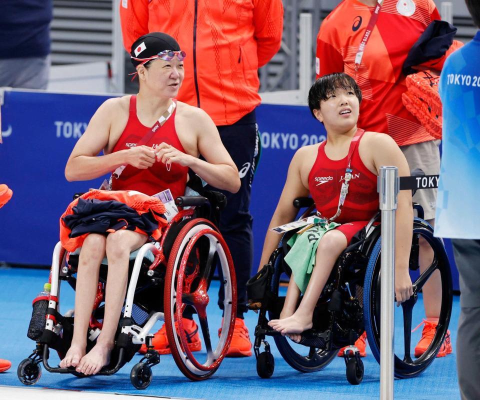 　東京五輪・女子１００メートル自由形（運動機能障害Ｓ５）予選のレースを終え、電光掲示板で結果を確認する成田真由美さん（左）と由井真緒里＝２０２１年
