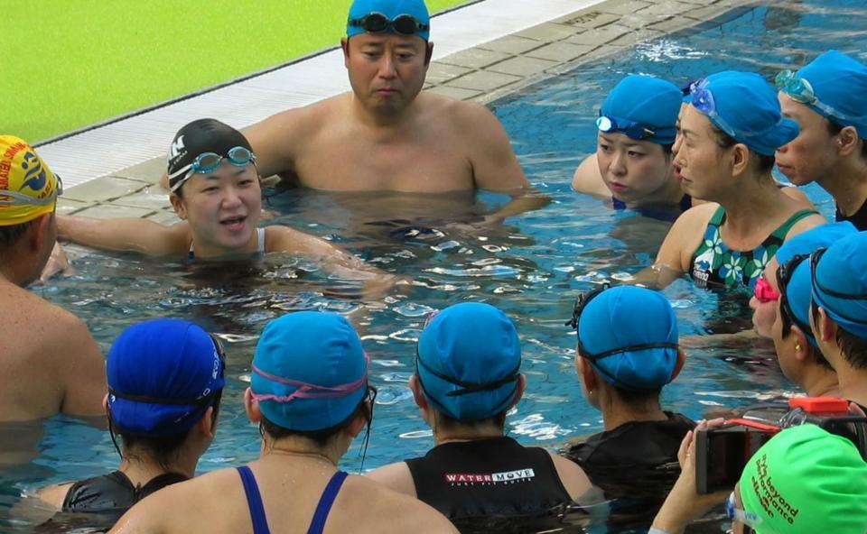　成田真由美さんからアドバイスを受ける障害者水泳ボランティアら＝２００４年