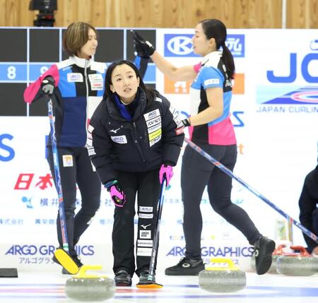 　ショットを決めタッチを交わすフォルティウス・吉村紗也香（左奥）と近江谷杏菜（右奥）の前で指示を出すロコ・ソラーレの藤沢五月（撮影・吉澤敬太）