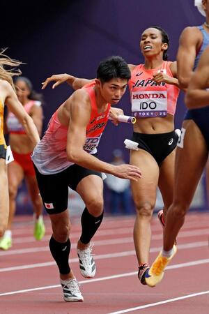 　混合１６００メートルリレー予選、第２走者の井戸アビゲイル風果（右）からバトンを受け駆け出す第３走者の吉津拓歩