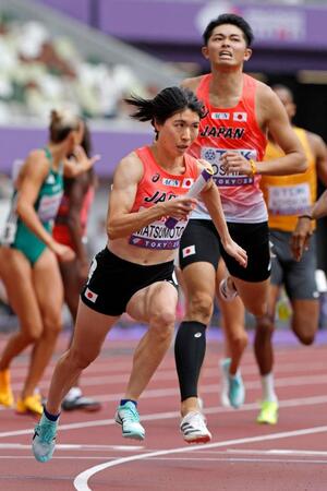 　第３走者の吉津拓歩（右）からバトンを受け力走するアンカーの松本奈菜子