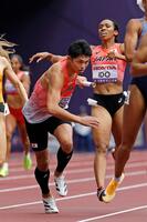 　混合１６００メートルリレー予選、第２走者の井戸アビゲイル風果（右）からバトンを受け駆け出す第３走者の吉津拓歩