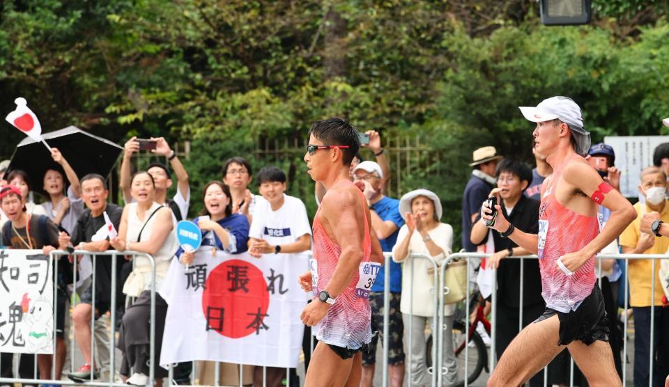 　男子３５キロ競歩で沿道からの応援を受けレースする勝木隼人（左）と川野将虎