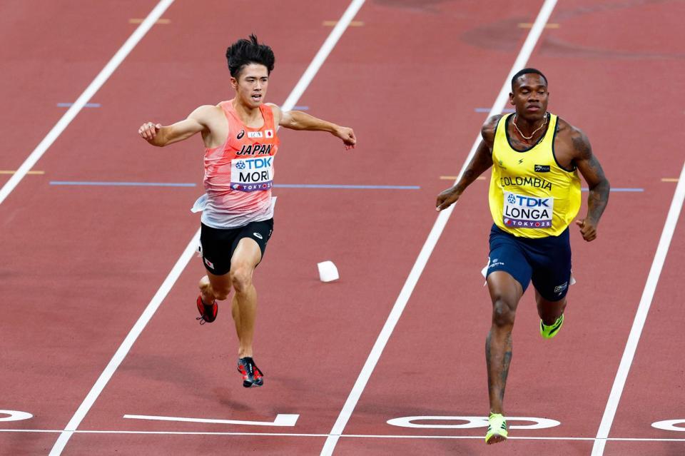 　男子１００メートル予選でゴールする守祐陽（左）