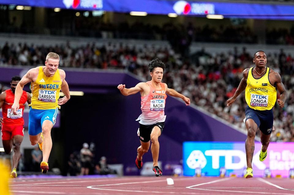 　男子１００メートル予選でゴールする守祐陽（中央）