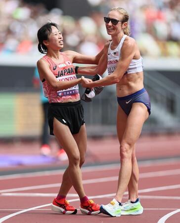 　ゴールし倒れ込んだ小林香菜（左）に手を差し伸べるスザンナ・サリバン