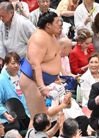 　懸賞金の束を手に引き上げる大の里（撮影・持木克友）