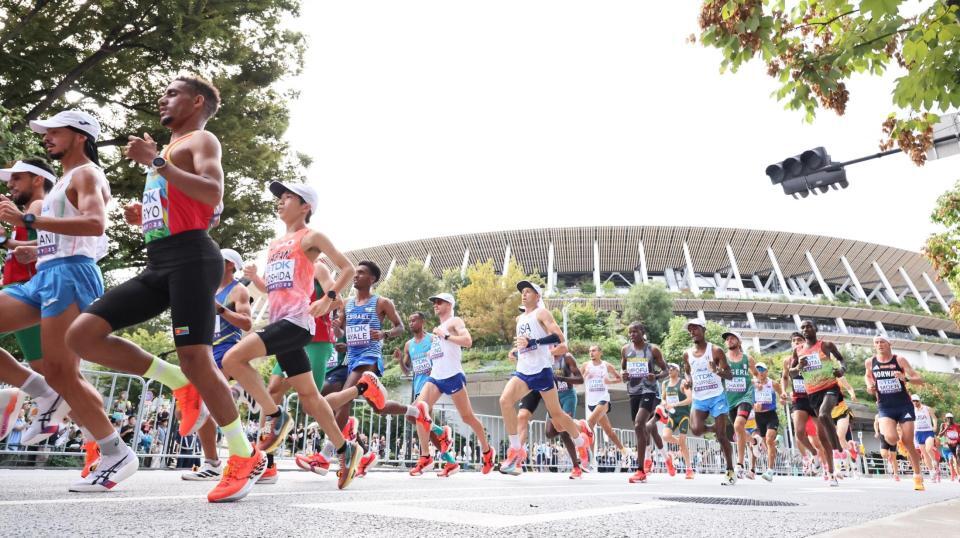 　国立競技場を背に力走する吉田祐也（左から３人目）ら