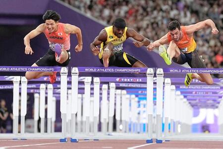 　男子１１０メートル障害準決勝で力走する野本周成（左）