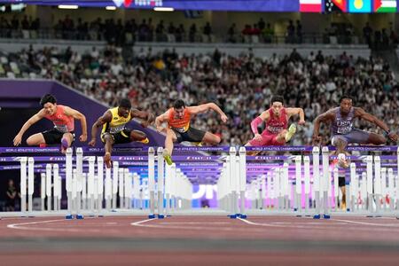 　男子１１０メートル障害準決勝で力走する野本周成（左端）