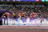 　男子１１０メートル障害準決勝で力走する野本周成（左端）