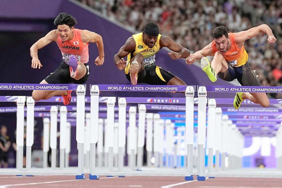 　男子１１０メートル障害準決勝で力走する野本周成（左）