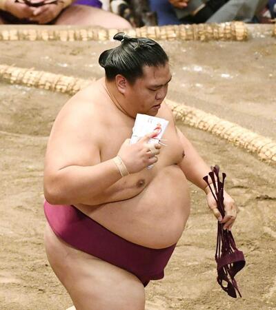 　白星をかみしめるように懸賞金を握り、土俵を下りる御嶽海（撮影・園田高夫）