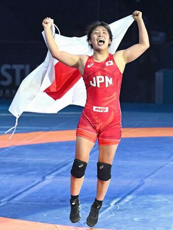 　女子５９キロ級で優勝し日の丸を手に喜ぶ尾西桜（共同）